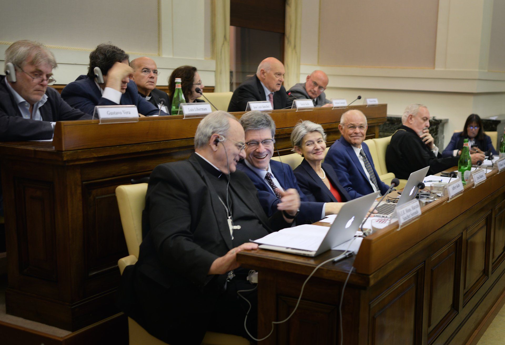 A group of people are sitting at a table with laptops.