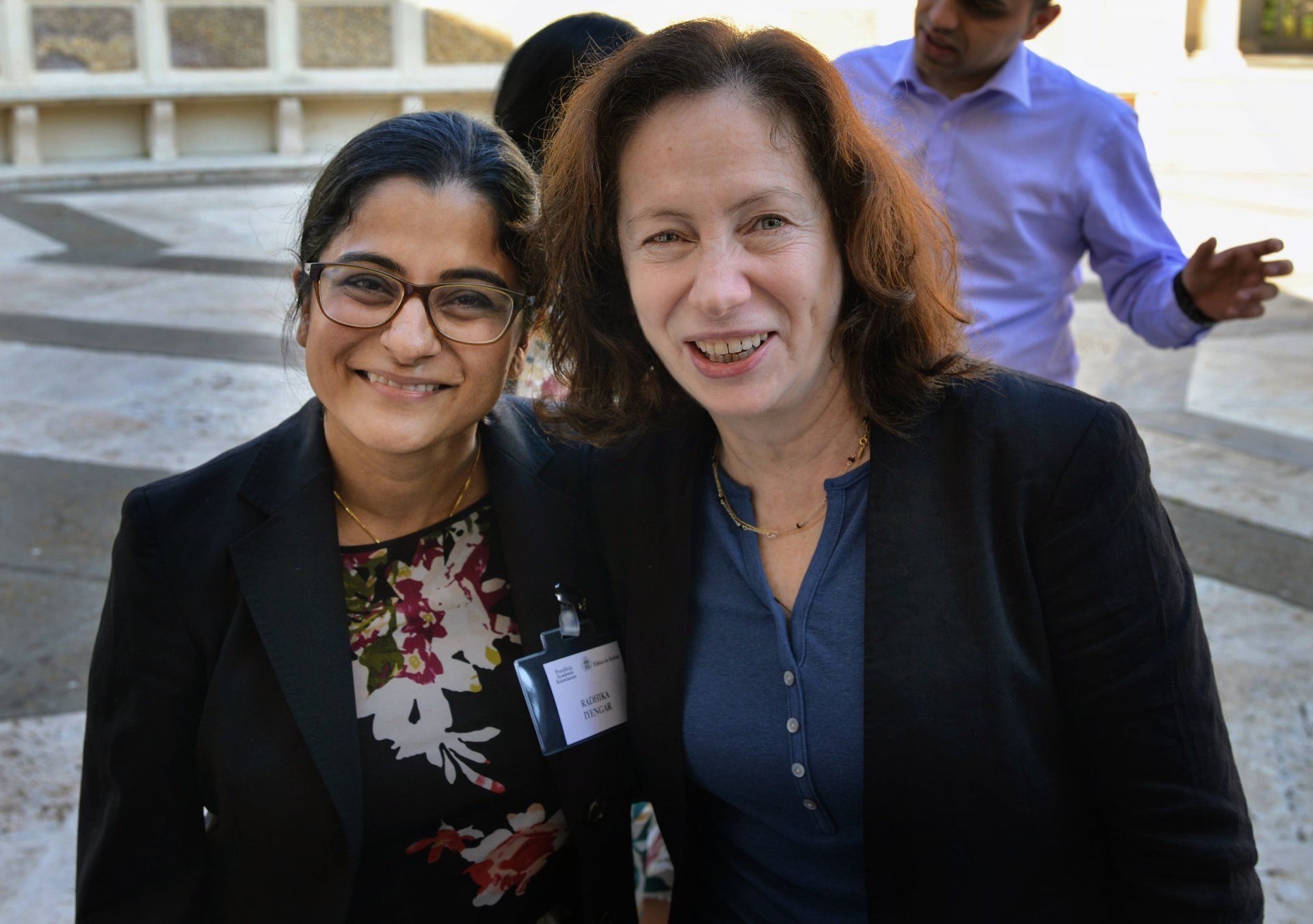 Two women are posing for a picture together and smiling for the camera.