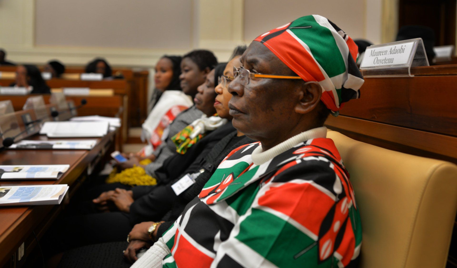 A group of people are sitting in a row in a room.