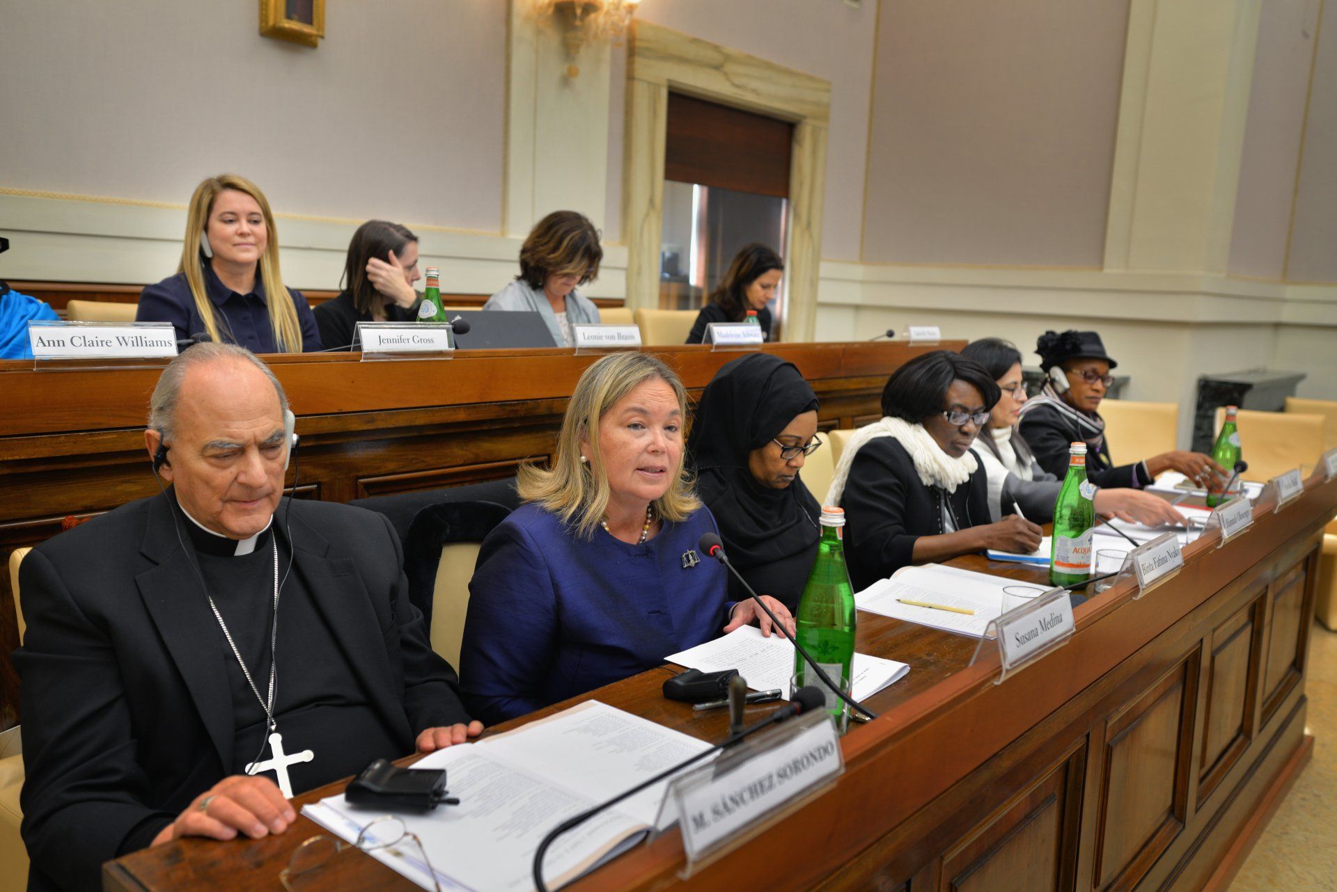 A group of people are sitting at a table with microphones.