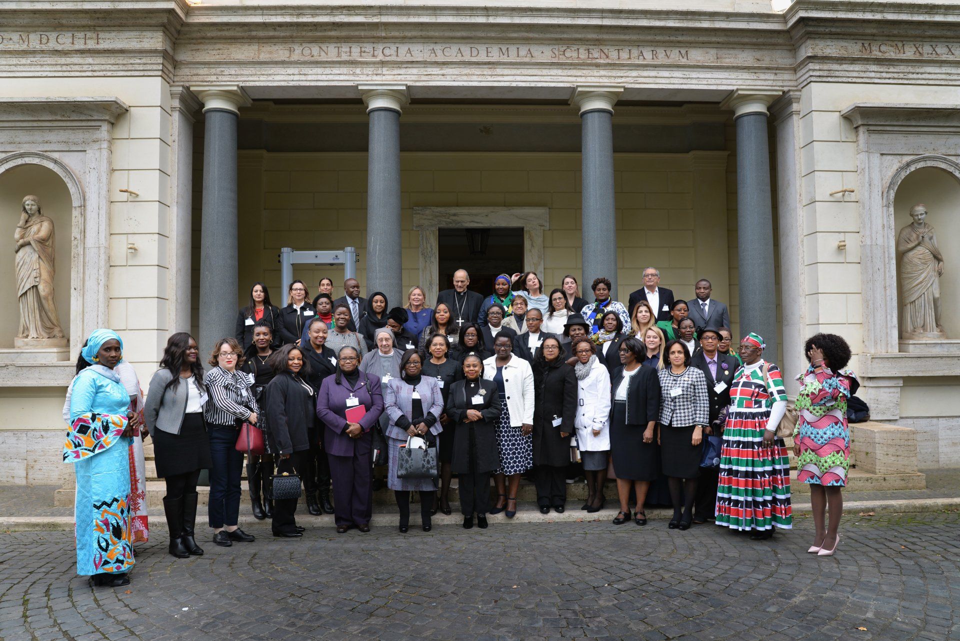 A large group of people are posing for a picture in front of a building.