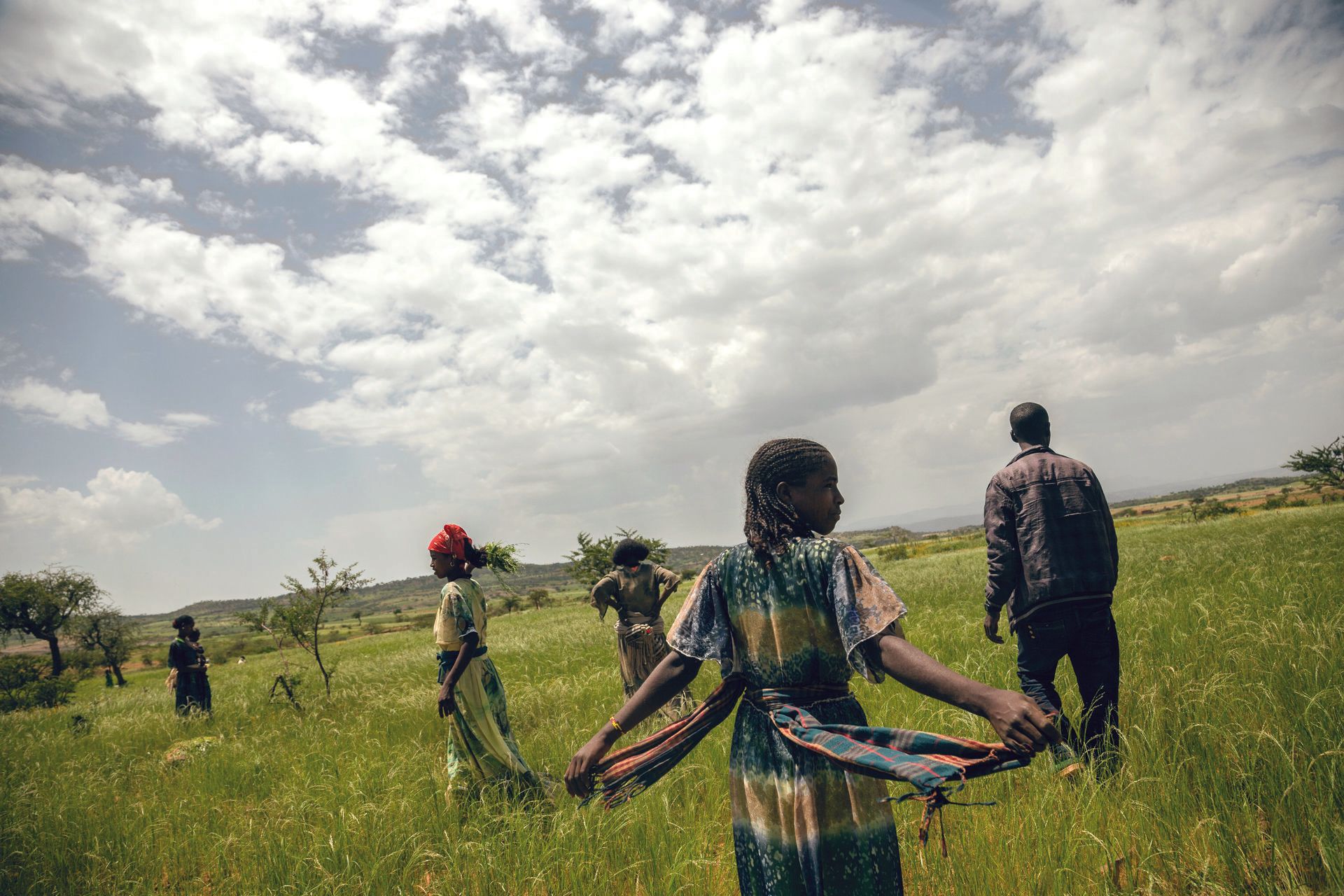 MVP: Young girls walking through a field in colorful clothing
