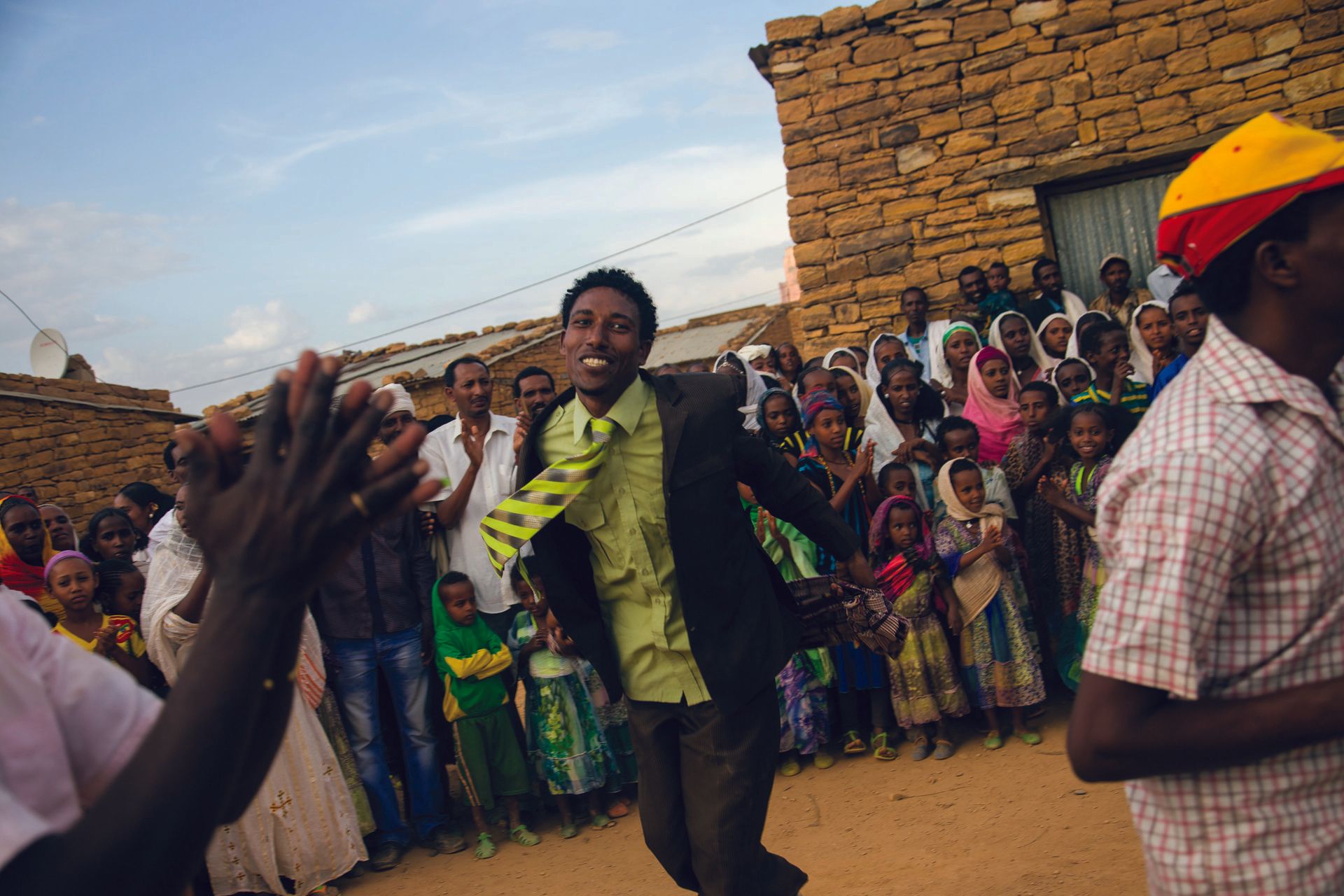 A man in a suit celebrates with the rest of the village people: Millennium Villages Project 
