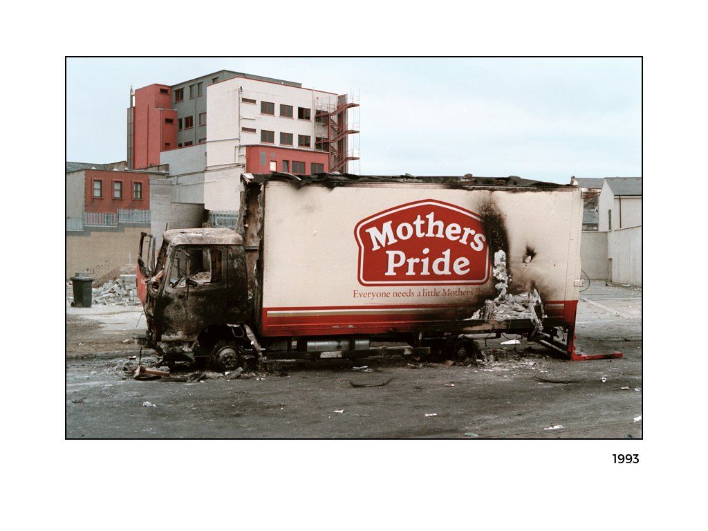 The Peace Project: A semi truck that was set on fire, now sitting charred and broken down Mothers Pride printed onto it