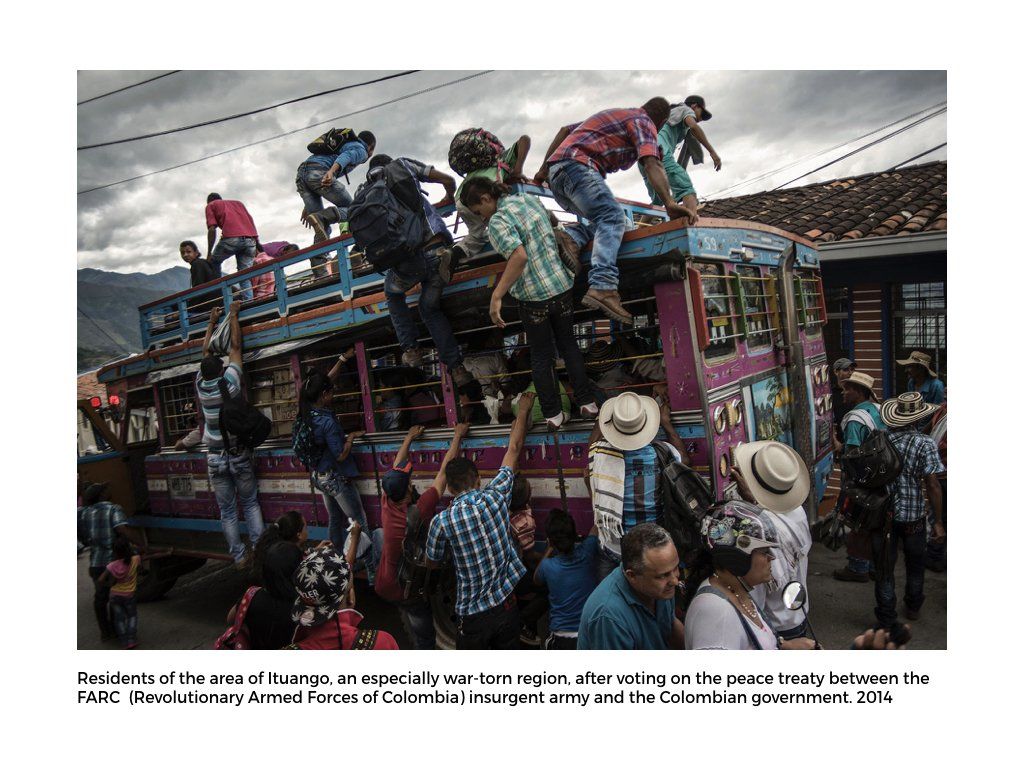 The Peace Project: People climbing and holding onto a bus after voting on the peace treaty in Colombia