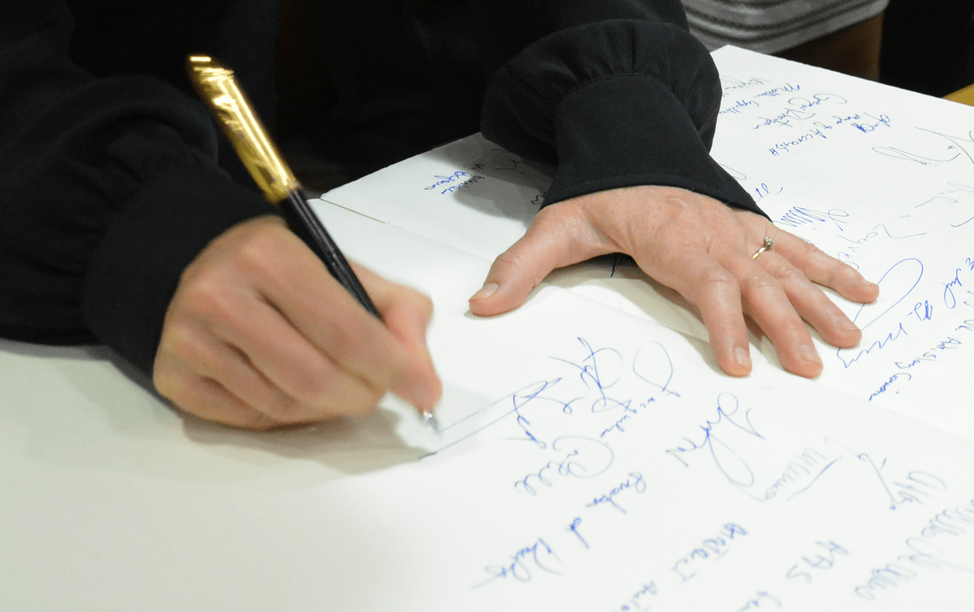 Jennifer Gross, Co-Founder of the Blue Chip Foundation, addresses modern climate change by signing a document