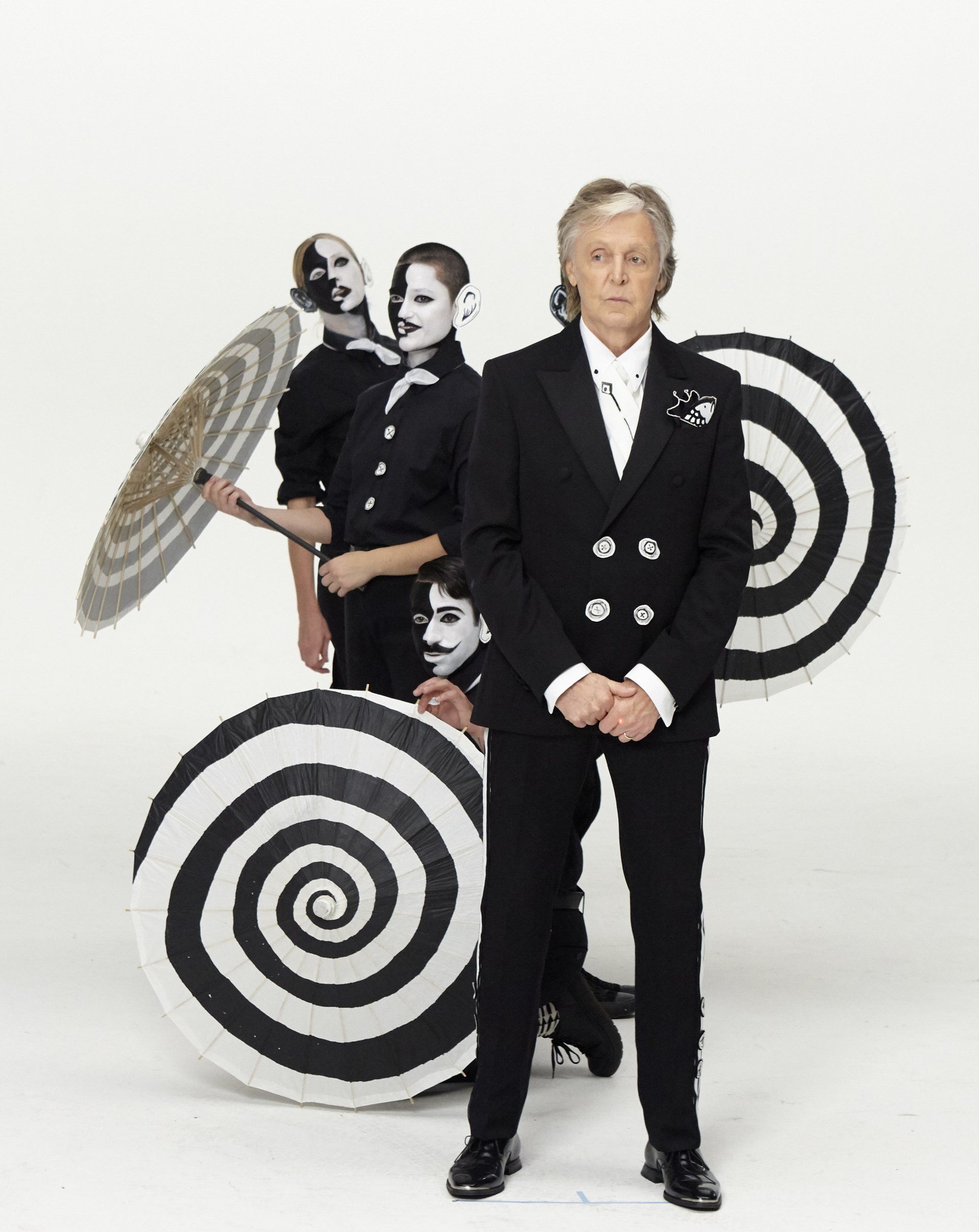 Paul McCartney , who cares I do campaign and men holding the umbrellas behind him