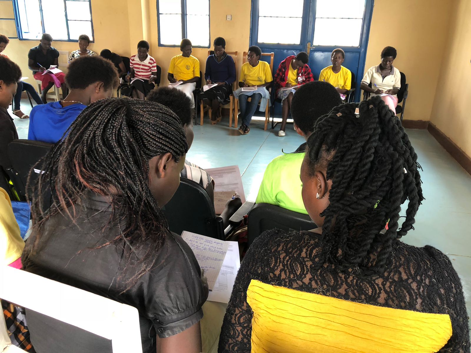A group of people are sitting in a circle in a room.