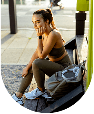 Woman in workout clothes resting, showing impact of hyperhidrosis and need for treatment at Hampstead Clinic