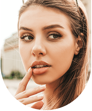 Woman touching her lip and looking away, highlighting who can benefit from lip enhancement at Hampstead Clinic