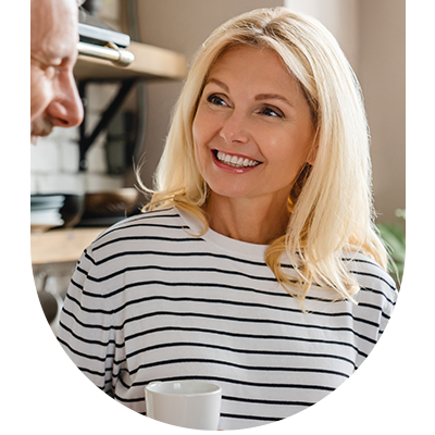 Woman in a stripy jumper smiling, representing personalised oral hygiene plans at Hampstead Clinic