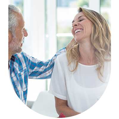 Woman smiling with her teeth visible to a man, demonstrating the benefits of restorative fillings at Hampstead Clinic