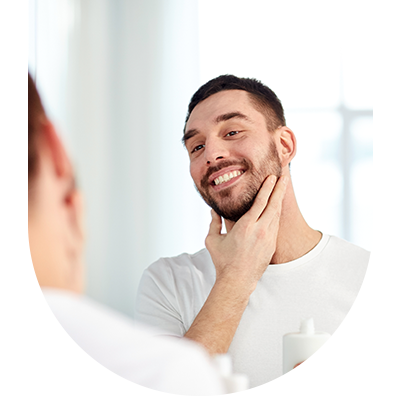 Young man smiling in the mirror, showing results of restorative fillings at Hampstead Clinic