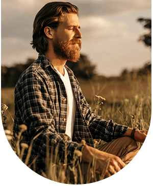 Man meditating in a field, symbolizing the benefits of sinus lifts for dental implants at Hampstead Clinic