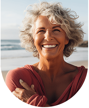 Lady smiling on a beach, reflecting confidence from dental treatments at Hampstead Clinic