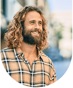 Man with long hair smiling, showcasing confidence after dental care at Hampstead Clinic