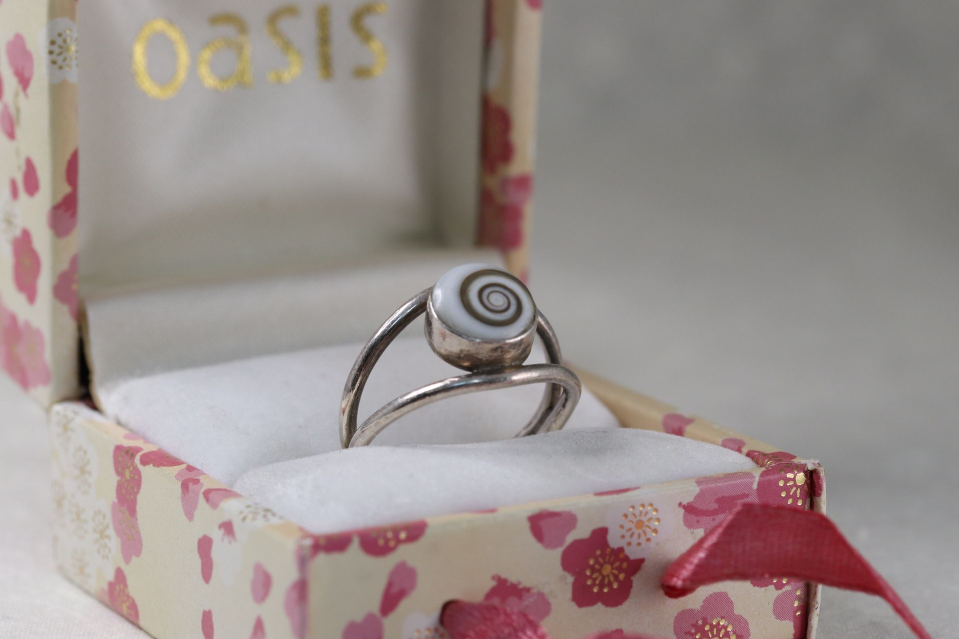 A ring is sitting in a box with flowers on it.