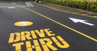 A drive thru sign is painted on the road