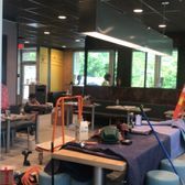 Interior of a cafe with construction tools on a table and a person sitting near windows.