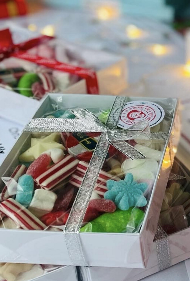 Gift boxes of Christmas candy, tied with silver ribbons.