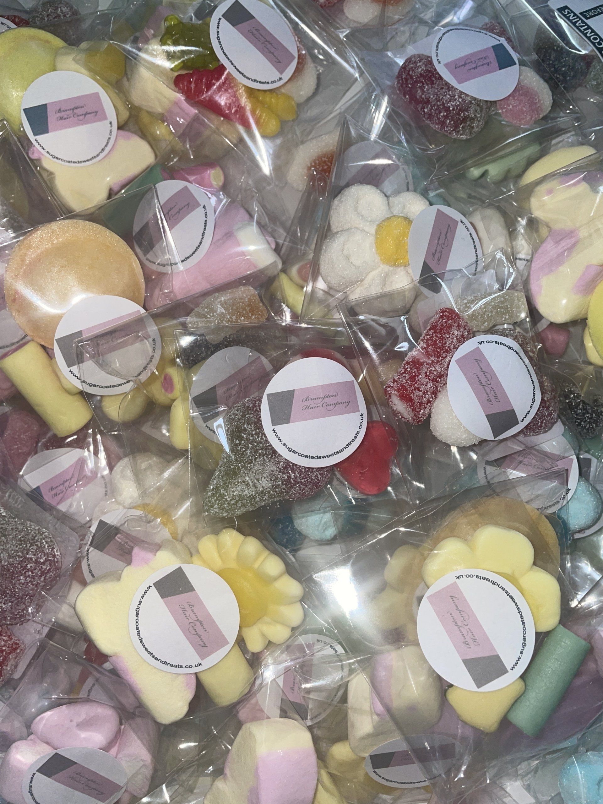 A bunch of bags of candy are sitting on a table.