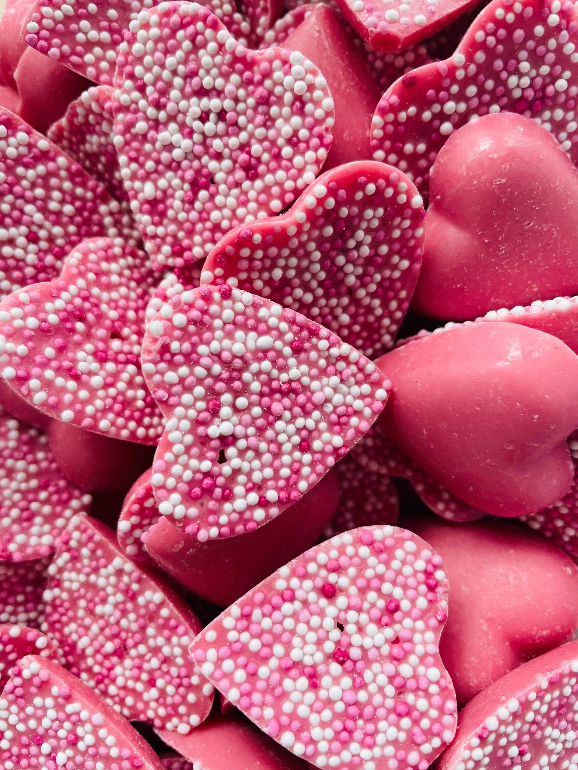 A pile of pink hearts with white sprinkles on them