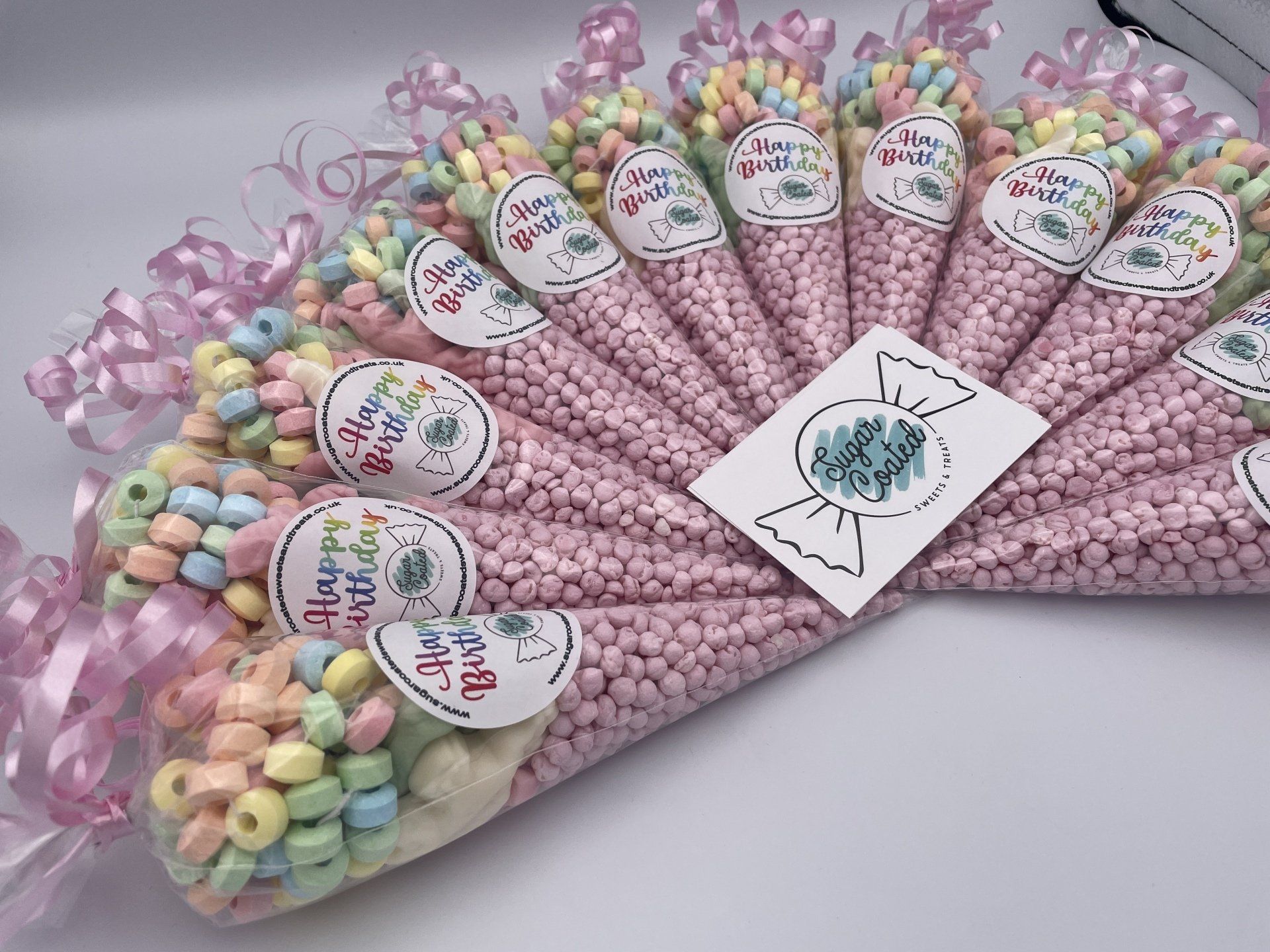 a bunch of pink cones filled with candy on a table .