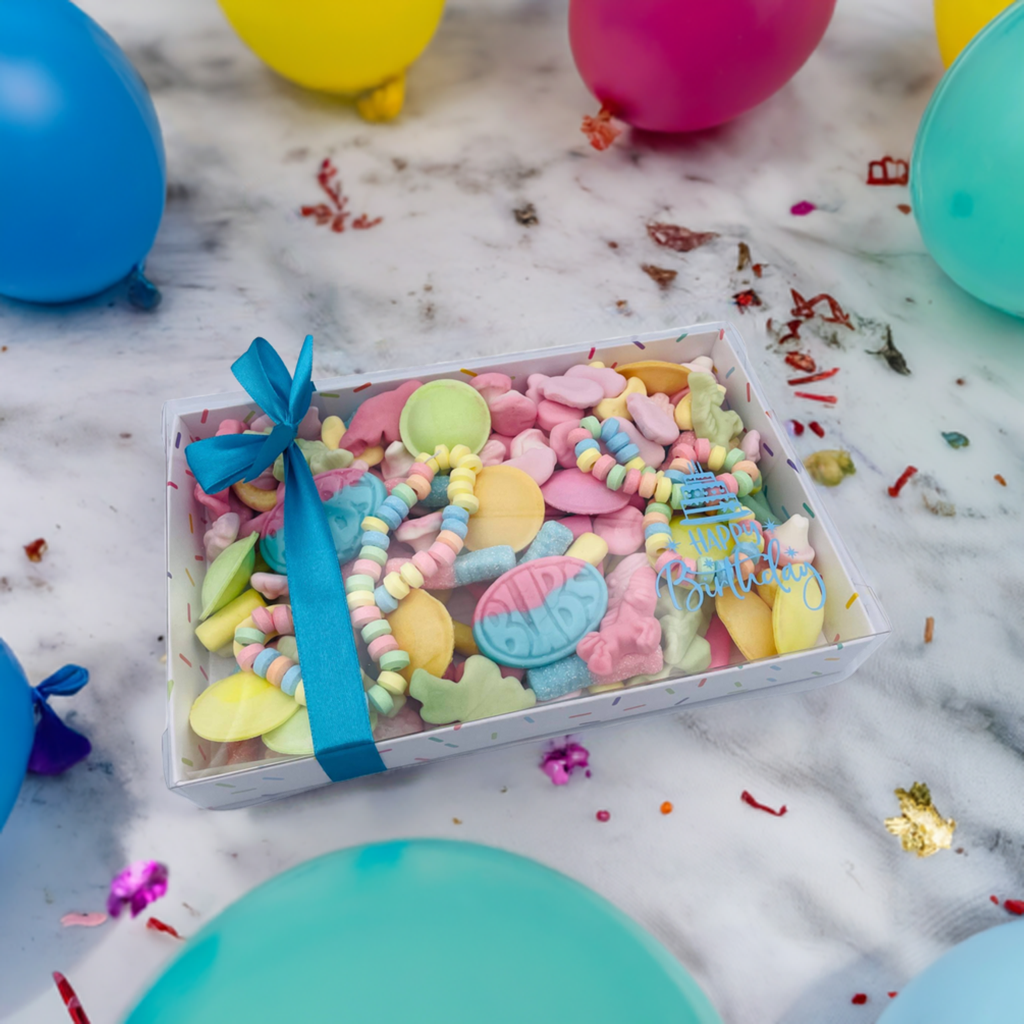 A box filled with candy and balloons on a table