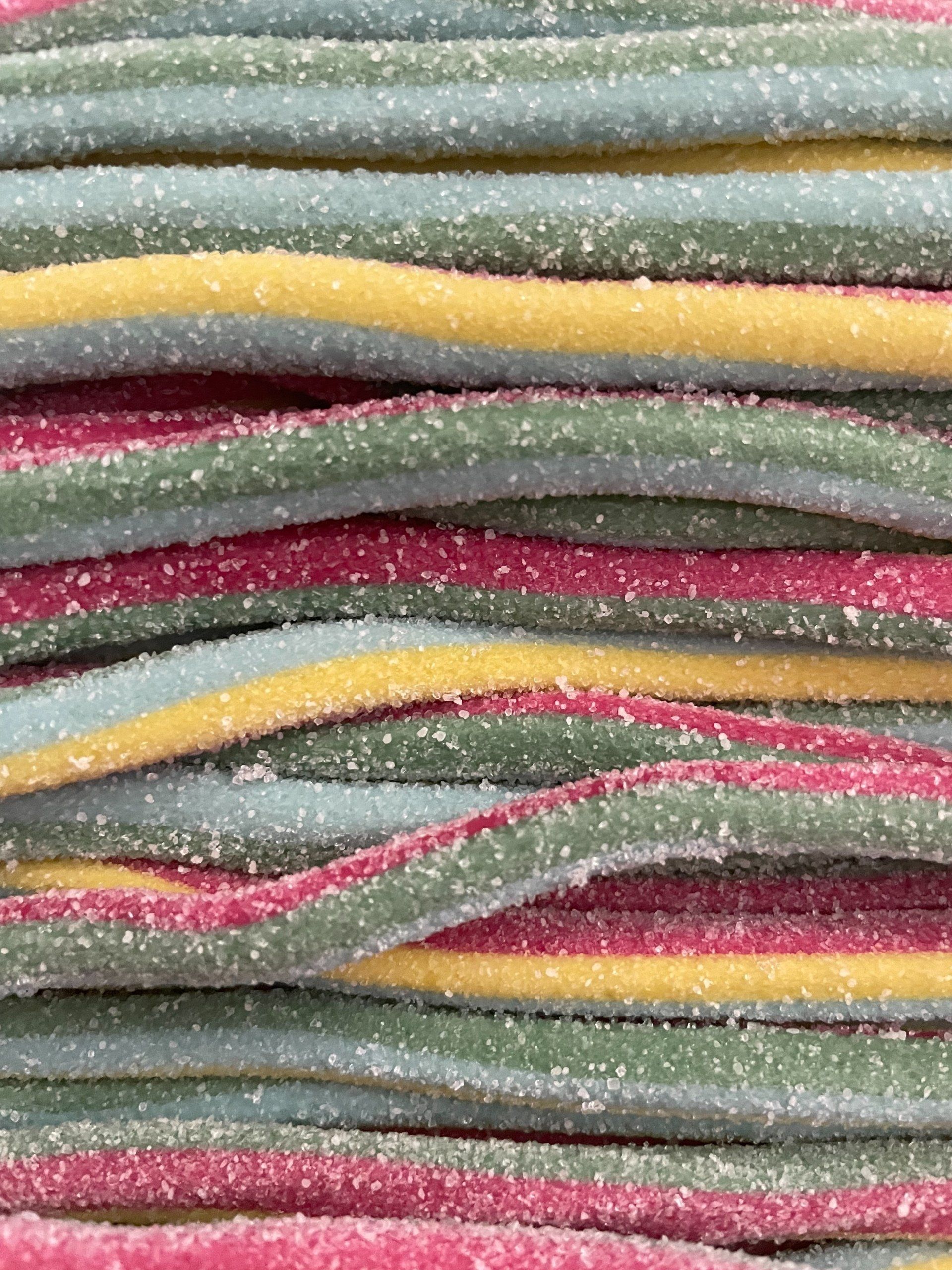 A close up of a stack of colorful candy sticks.