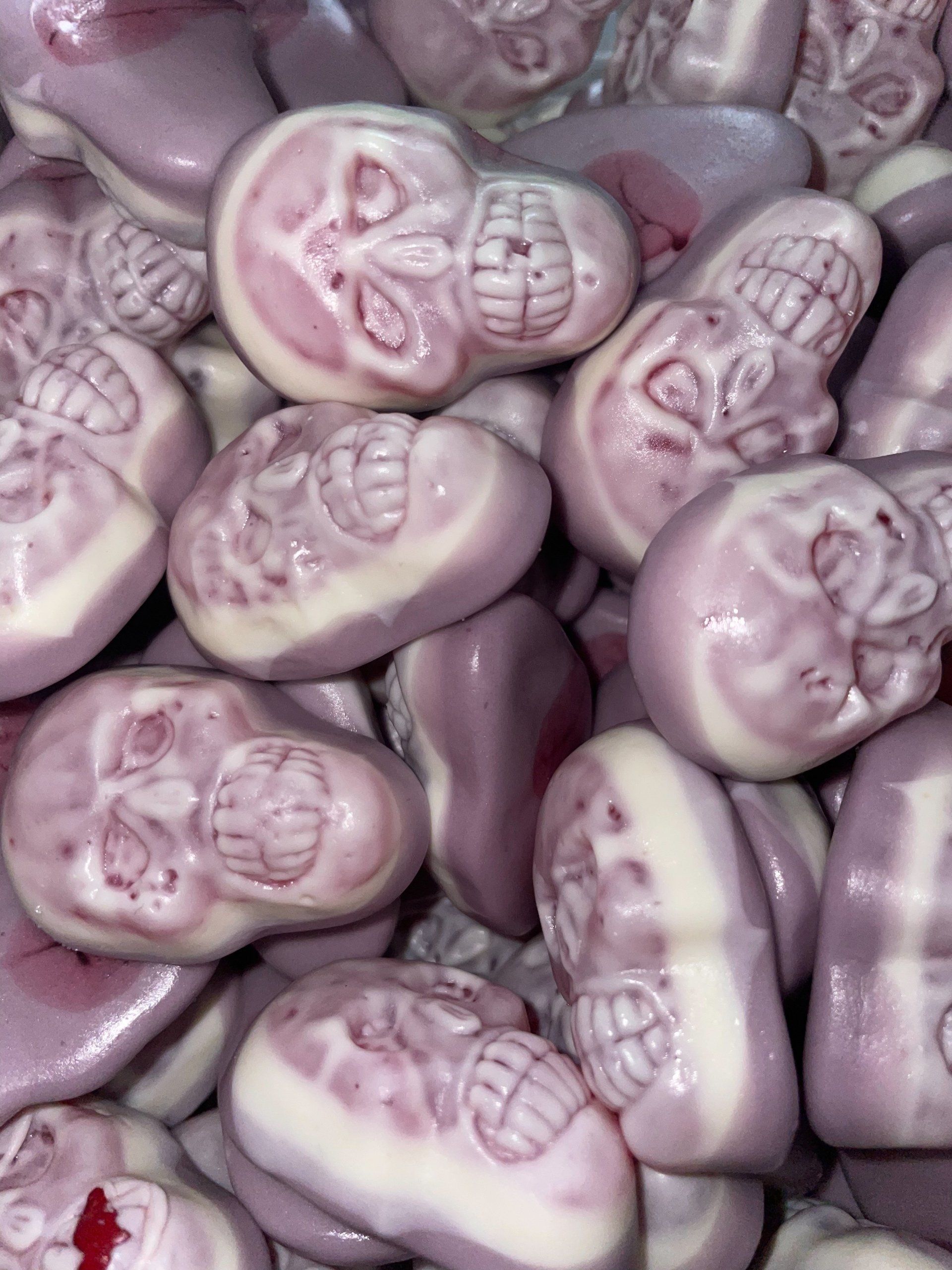 A pile of purple and white candy with skulls on them