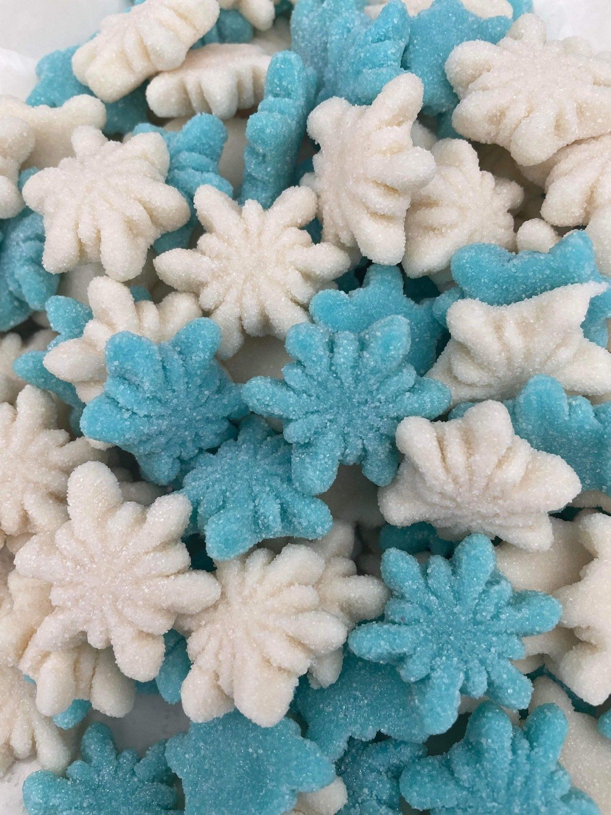 A pile of blue and white snowflakes on a white surface.