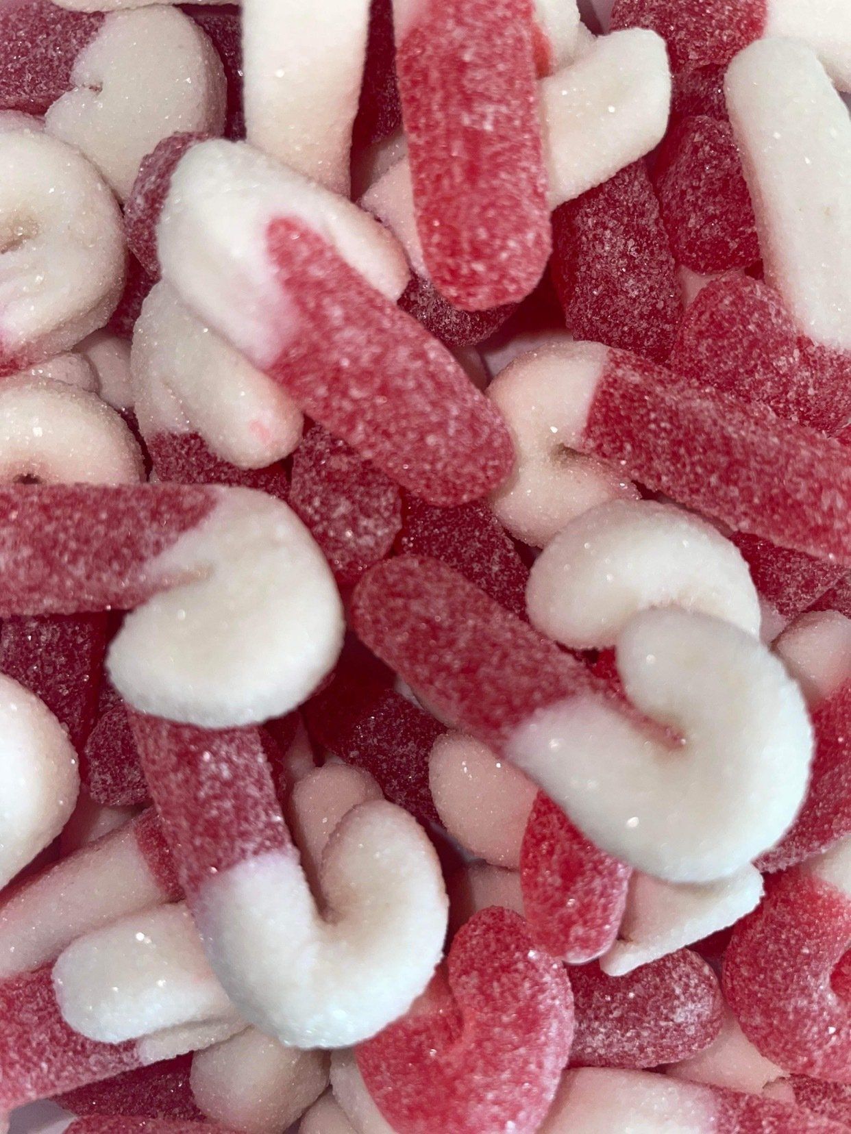 A close up of a pile of red and white candy canes