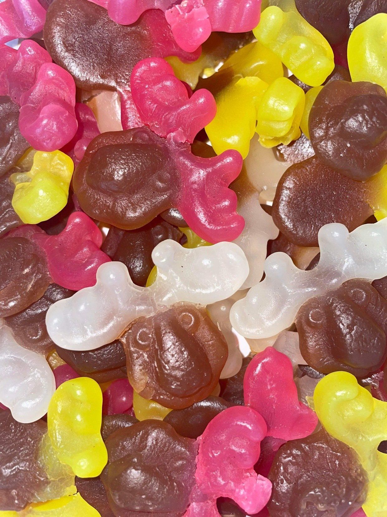 A pile of gummy bears of different colors and shapes