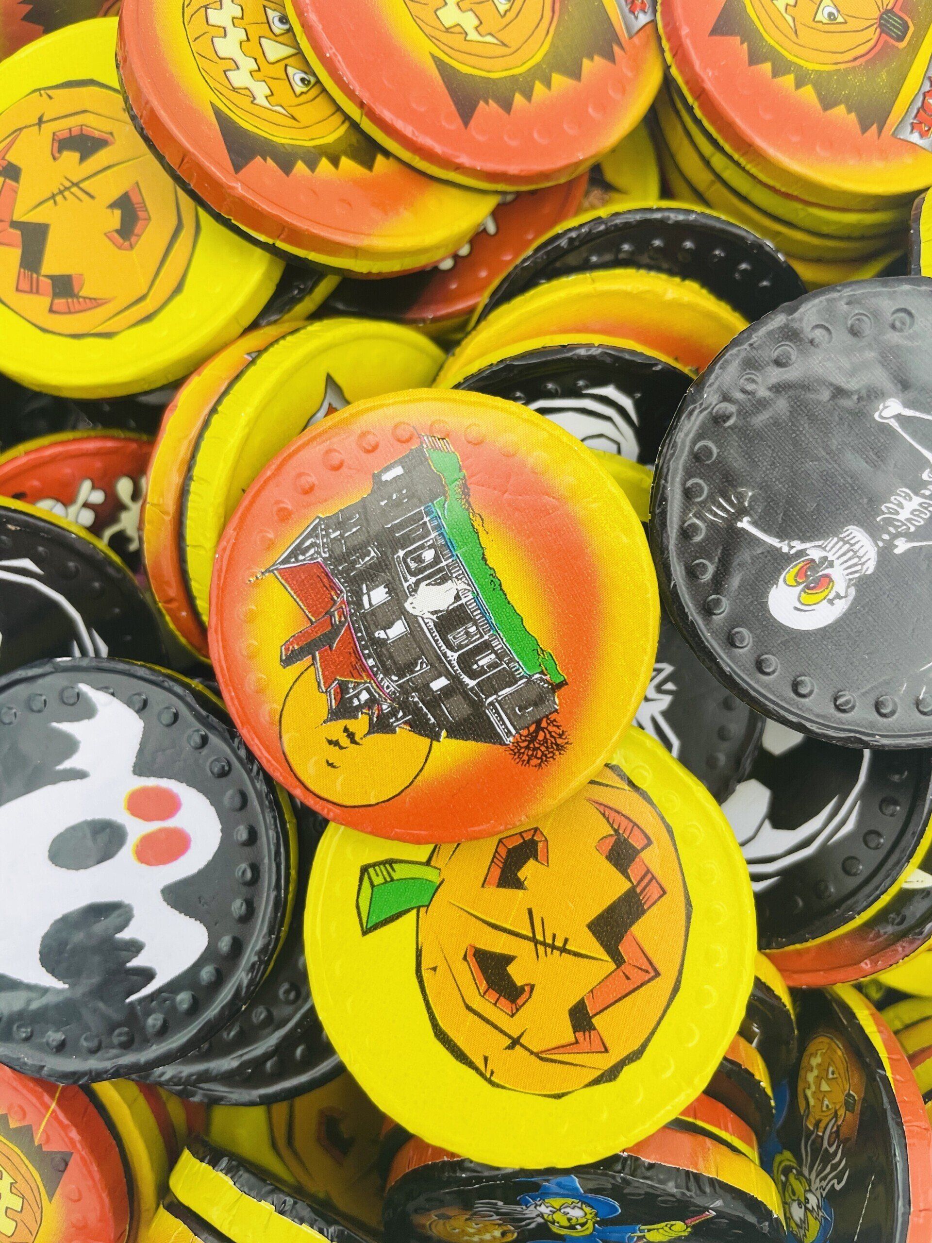 A pile of halloween tokens with a ghost and pumpkin on them