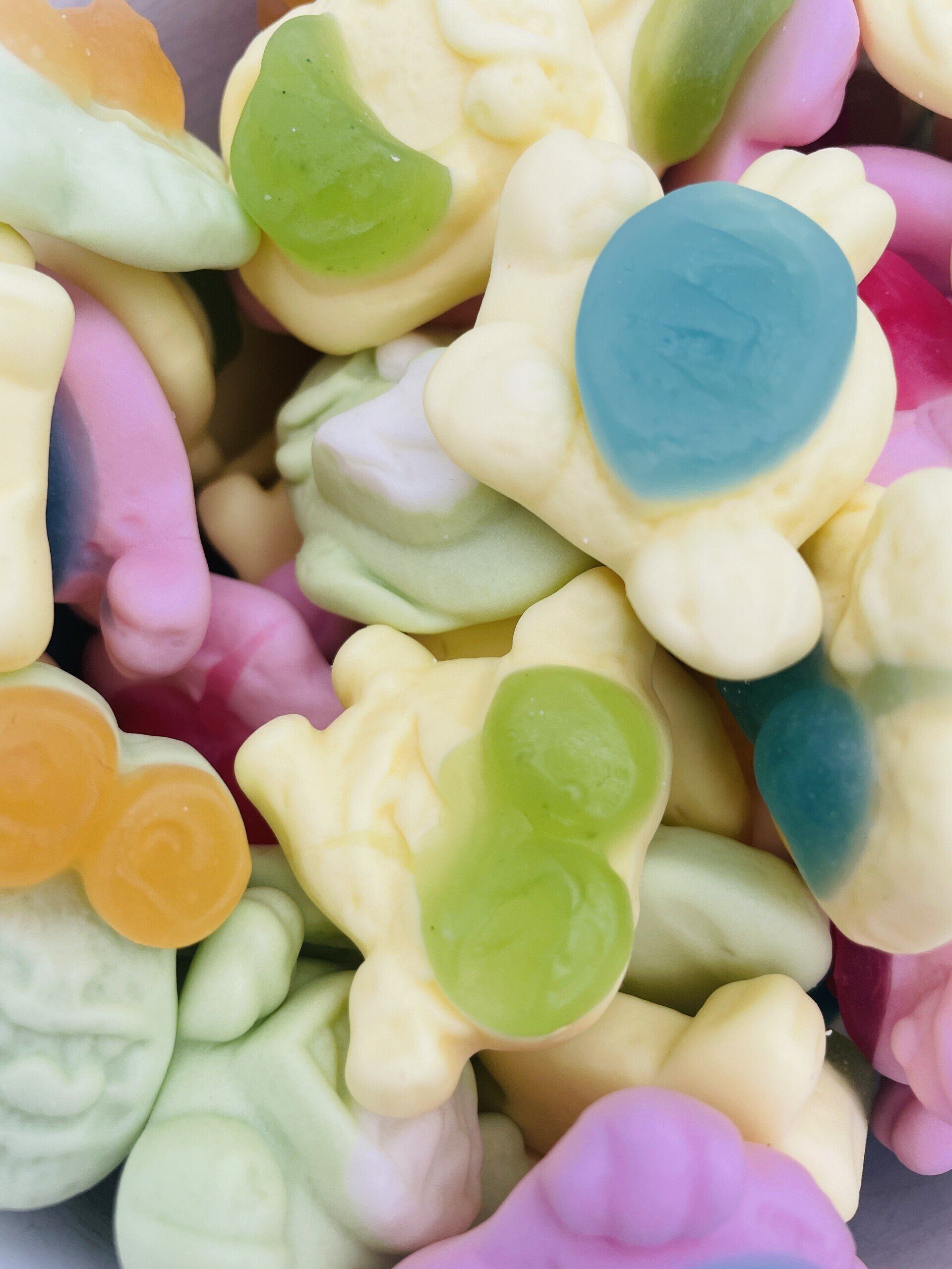 A pile of colorful gummy bears with the letter m on them