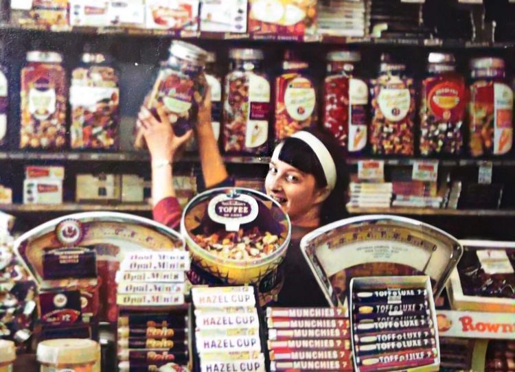 A woman is holding a jar of candy in a store