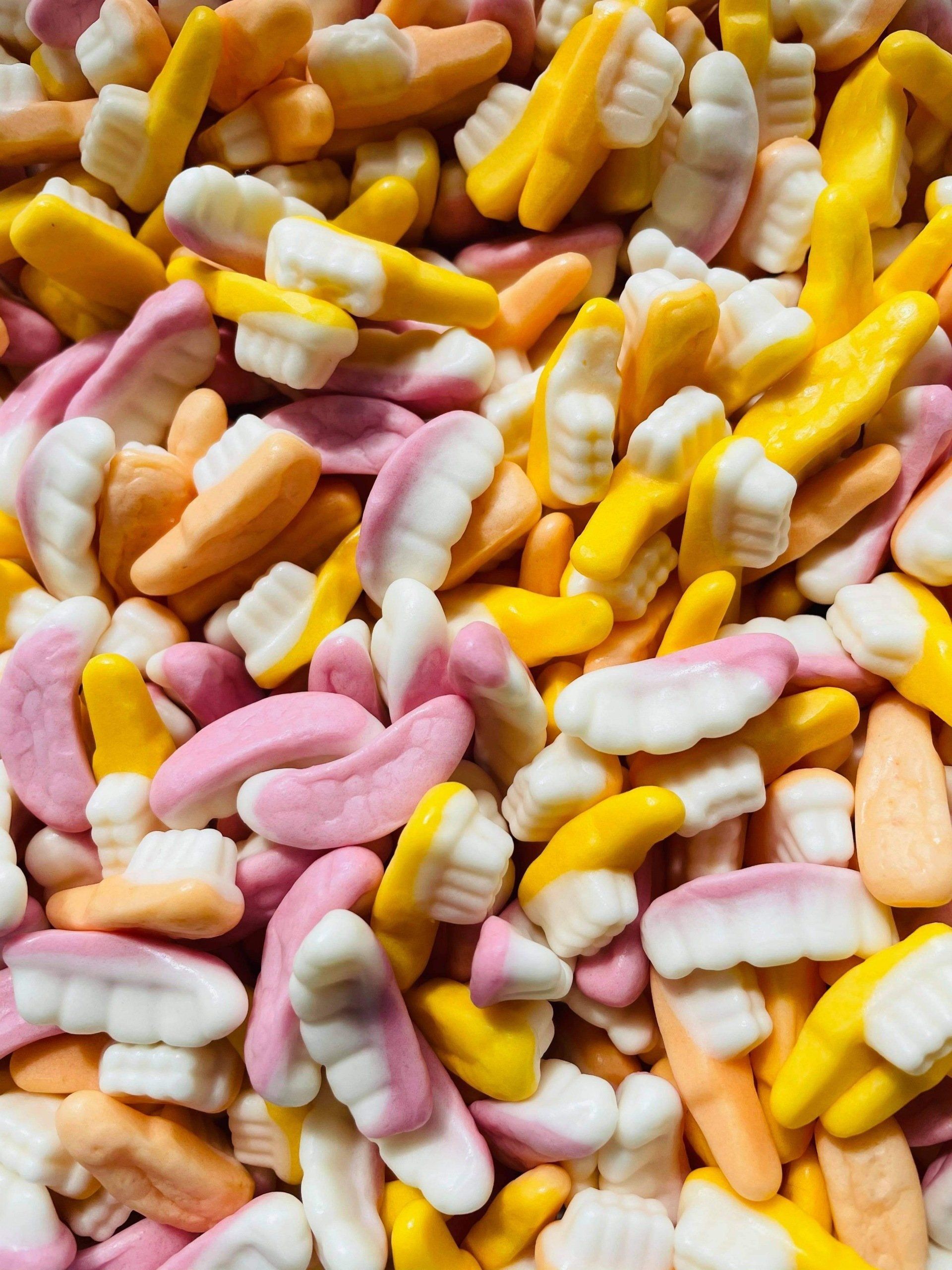 A pile of candy in the shape of teeth and thumbs up