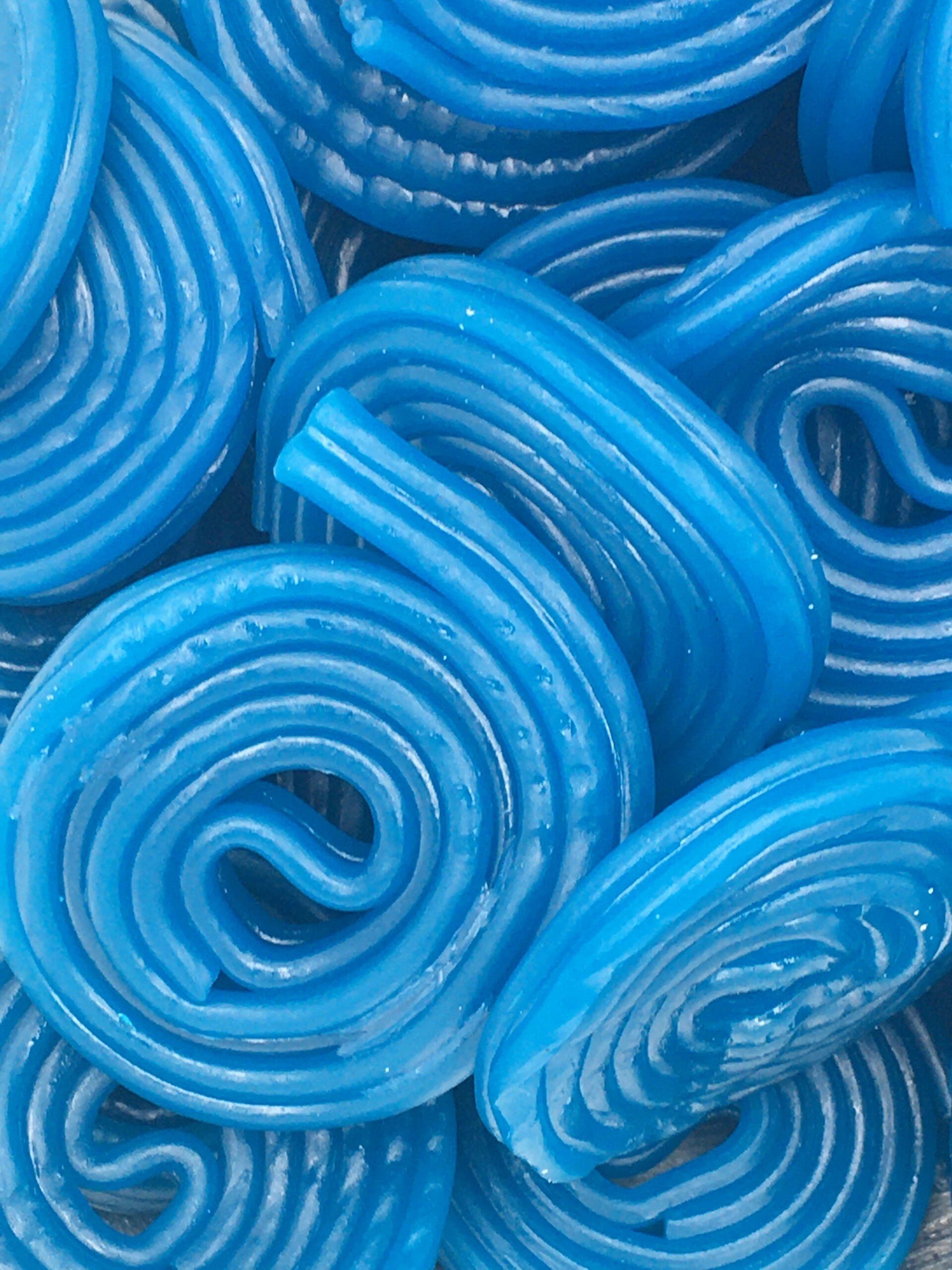 A close up of a pile of blue licorice swirls.