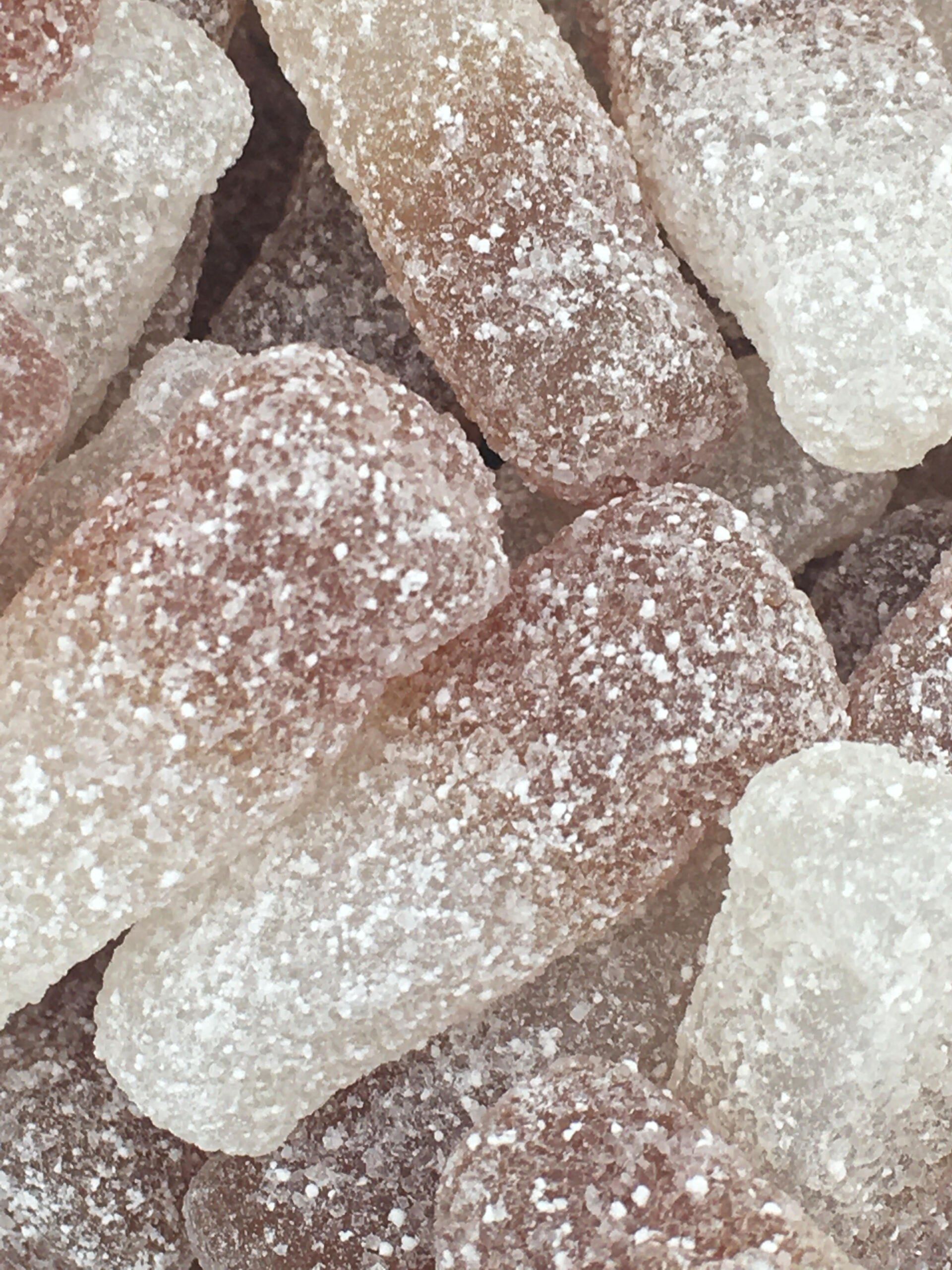 A close up of a pile of gummy soda bottles