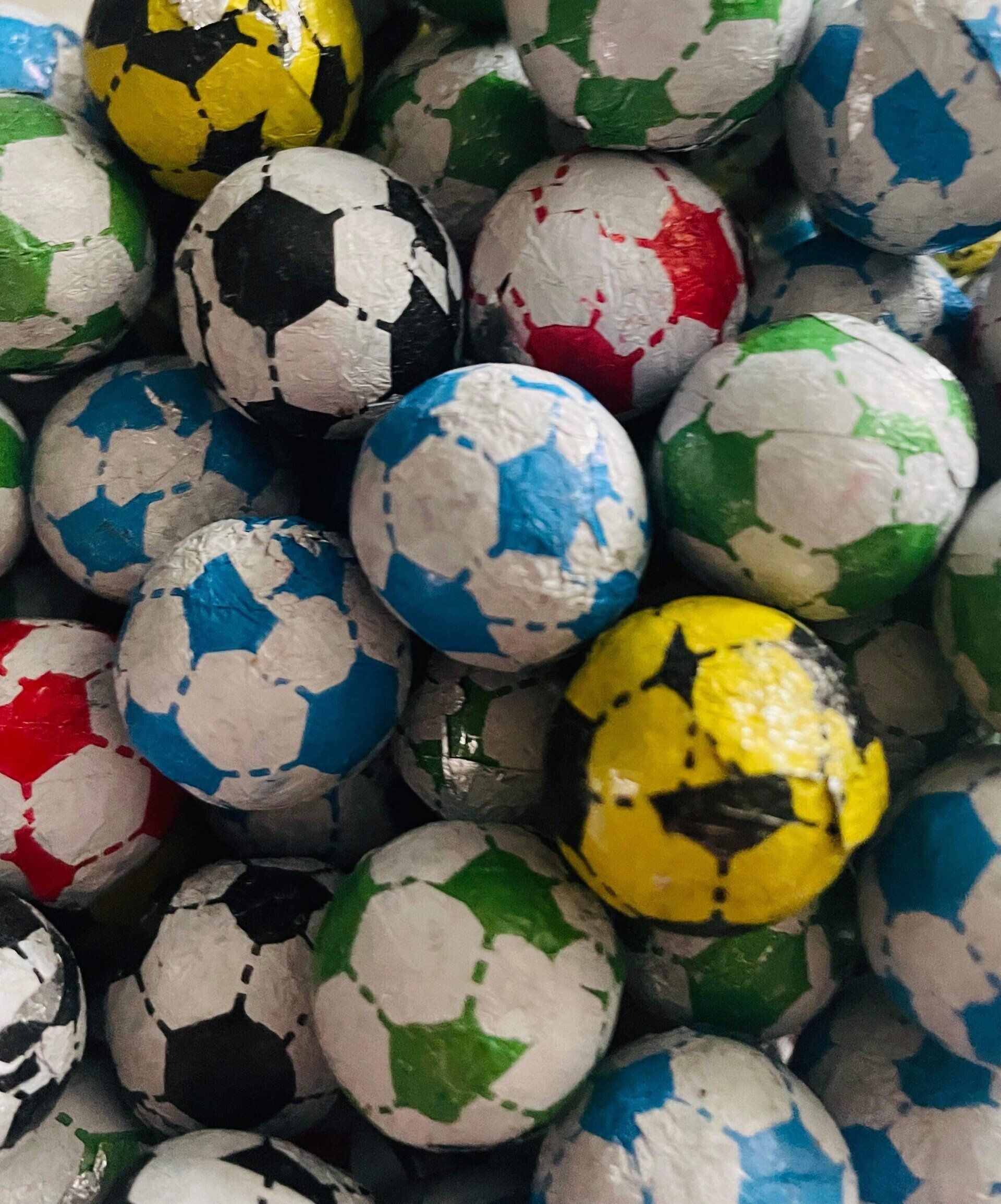 A pile of colorful soccer balls are stacked on top of each other