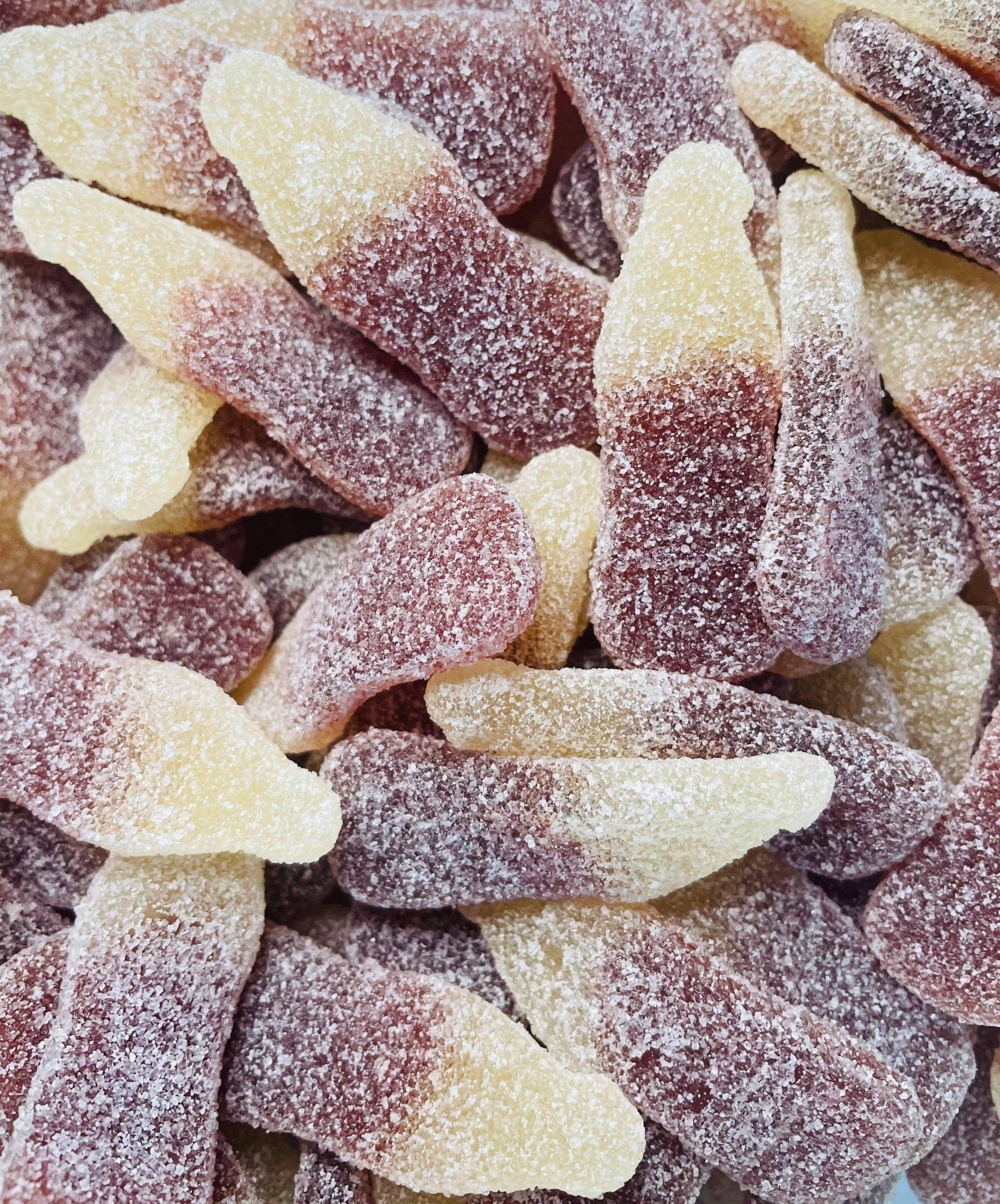 A close up of a pile of gummy cola bottles