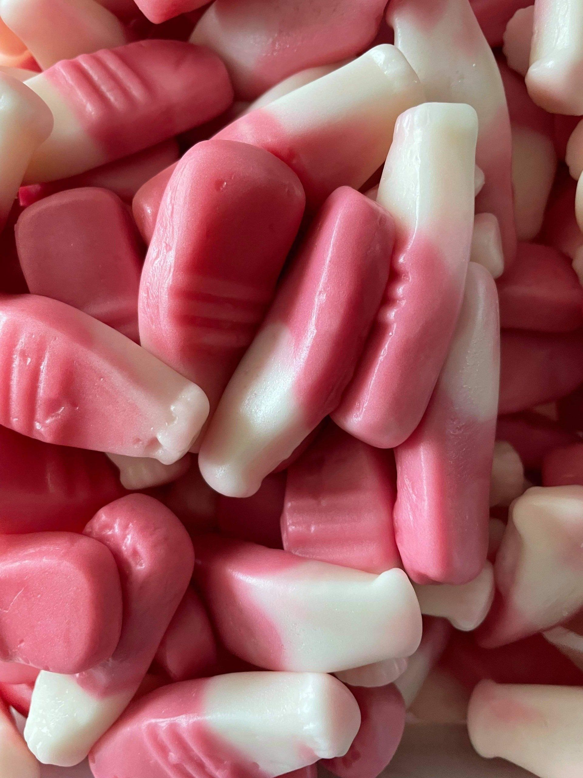 A pile of pink and white candy in the shape of toothpicks.