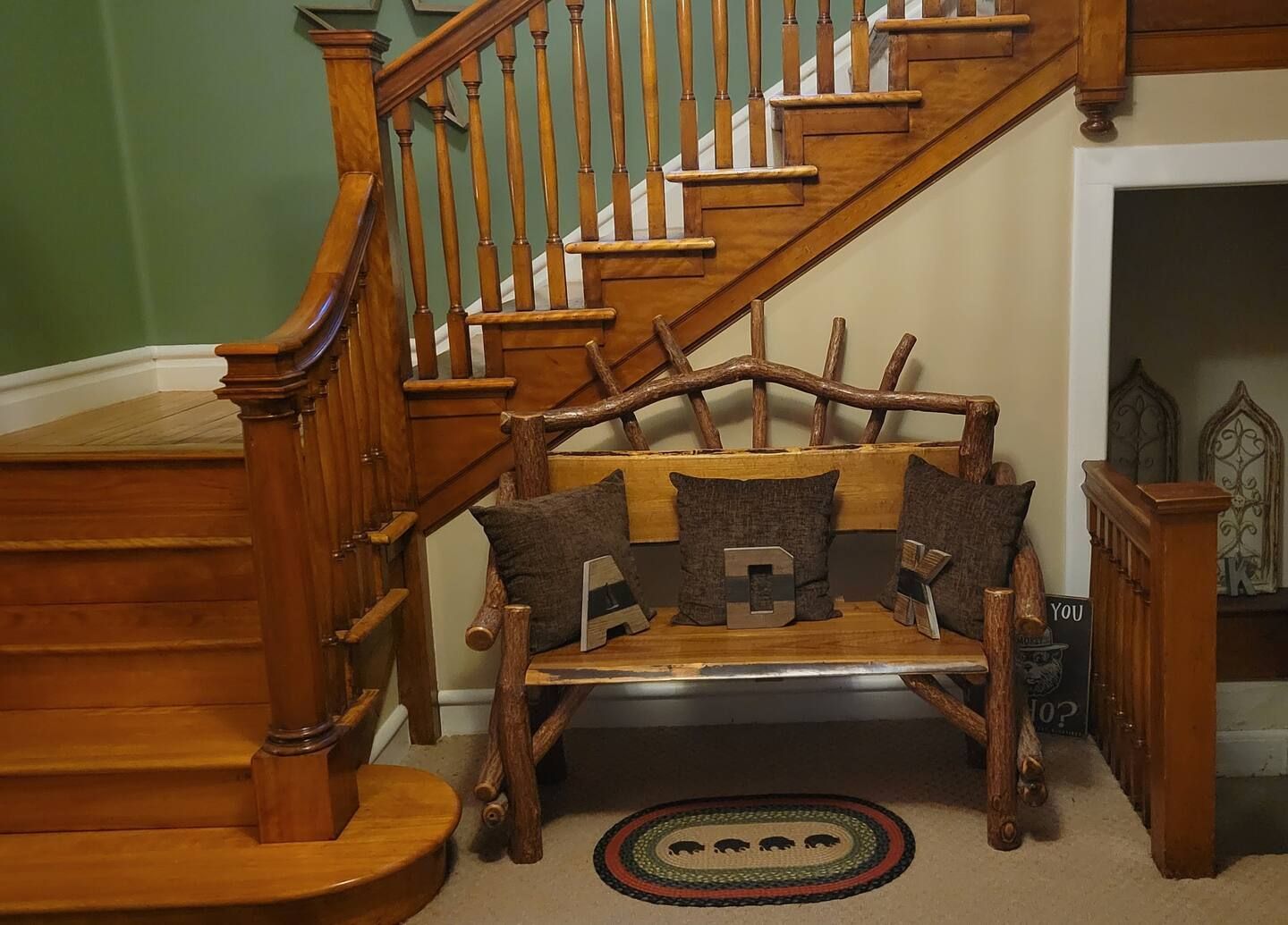 A wooden bench in front of a wooden staircase