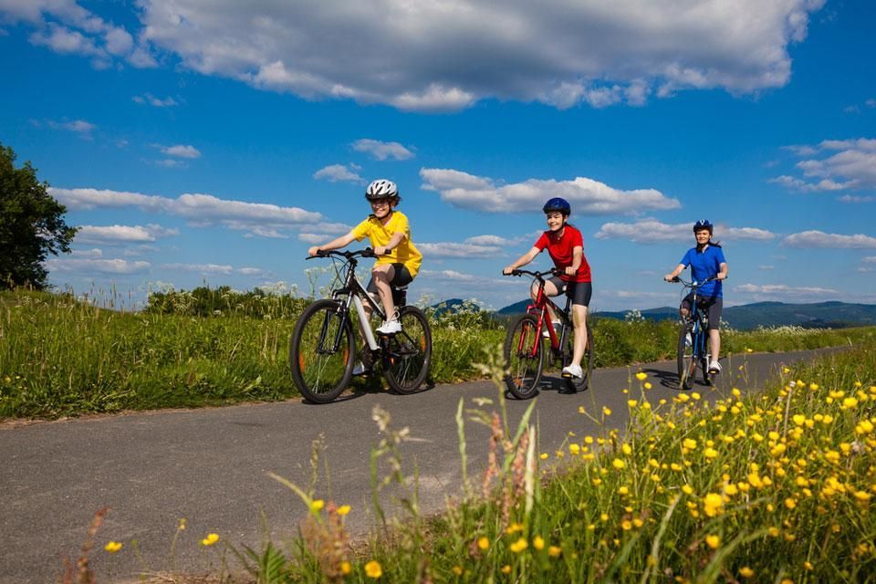 A group of people are riding bicycles down a road.