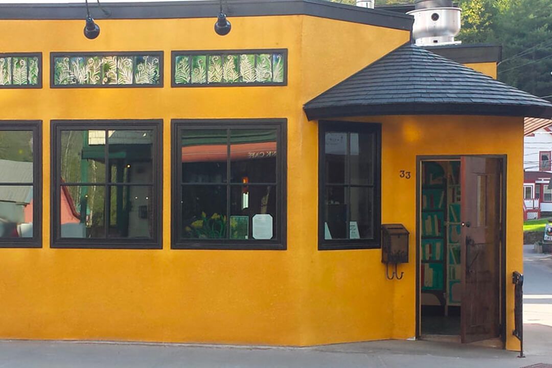 A yellow building with black windows and a black roof