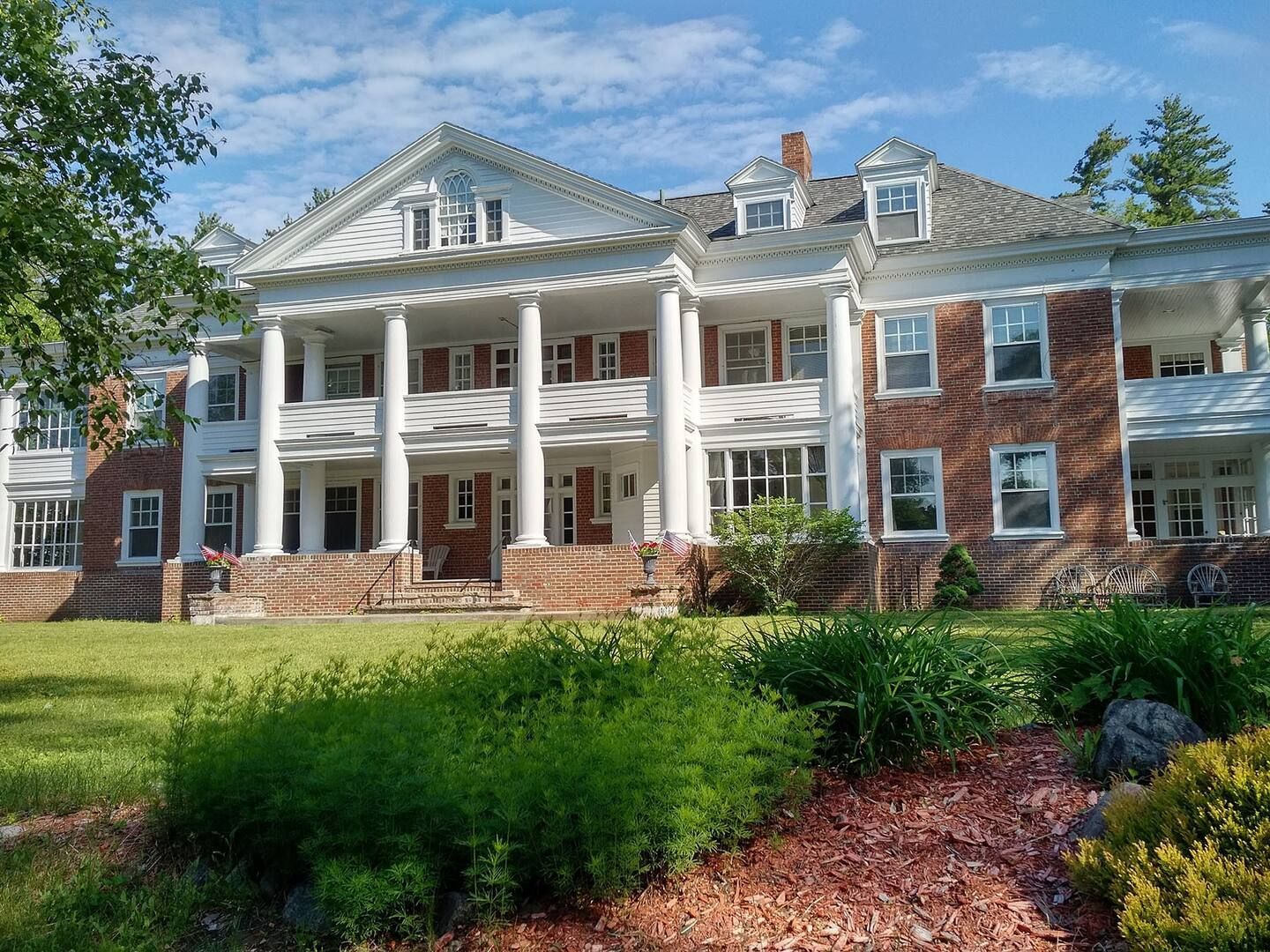 A large brick house with white columns and a large porch
