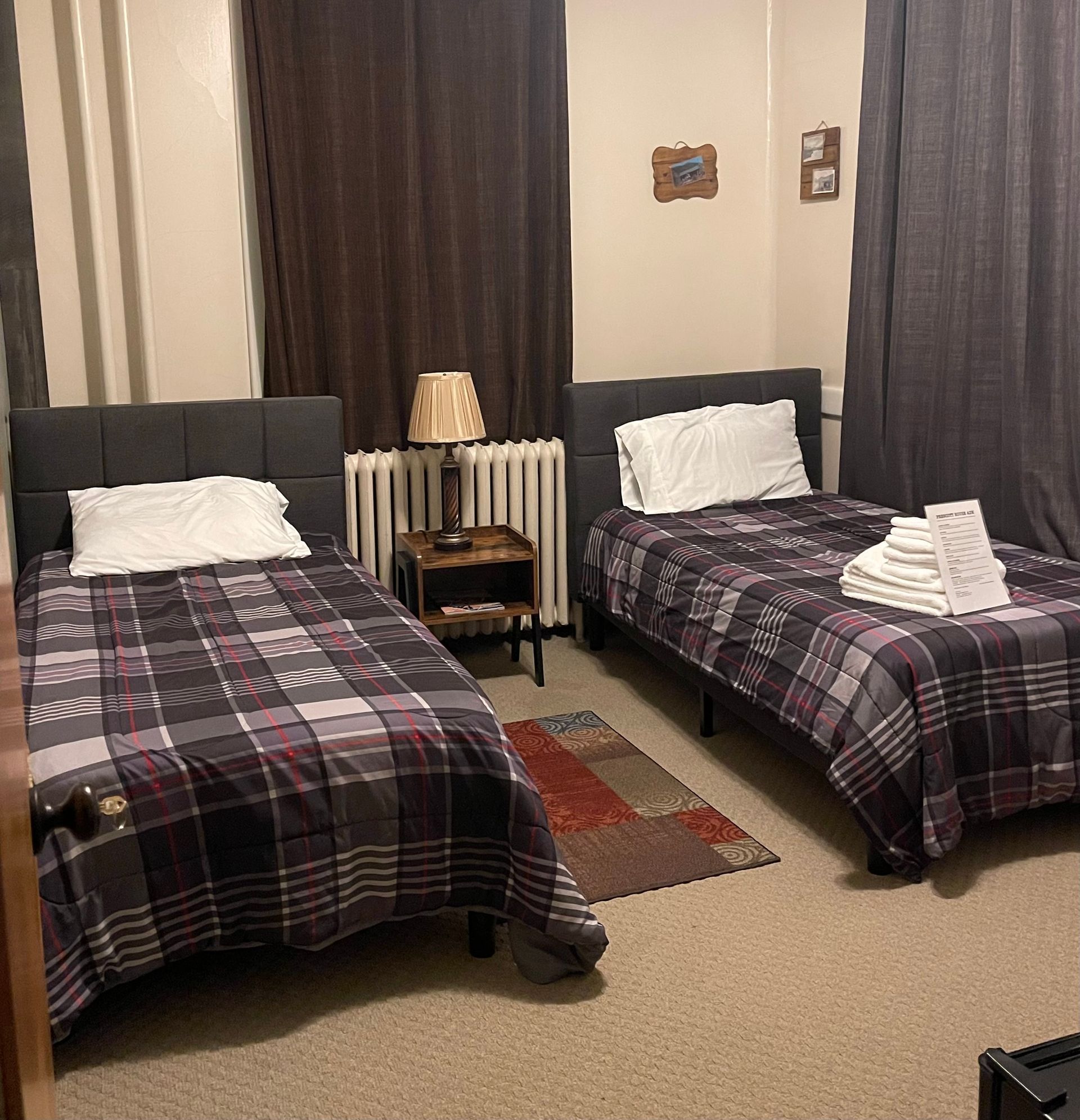 A bedroom with two beds and a lamp