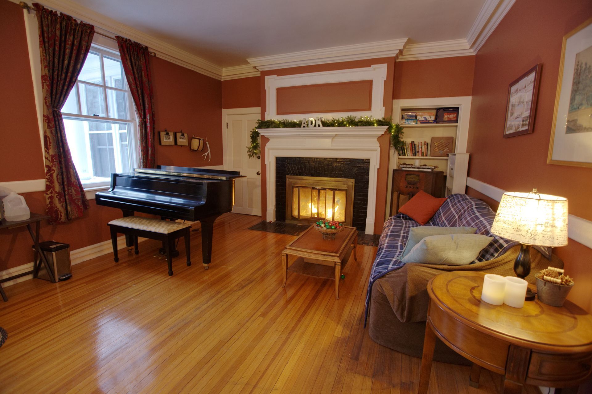 A living room with a piano and a fireplace