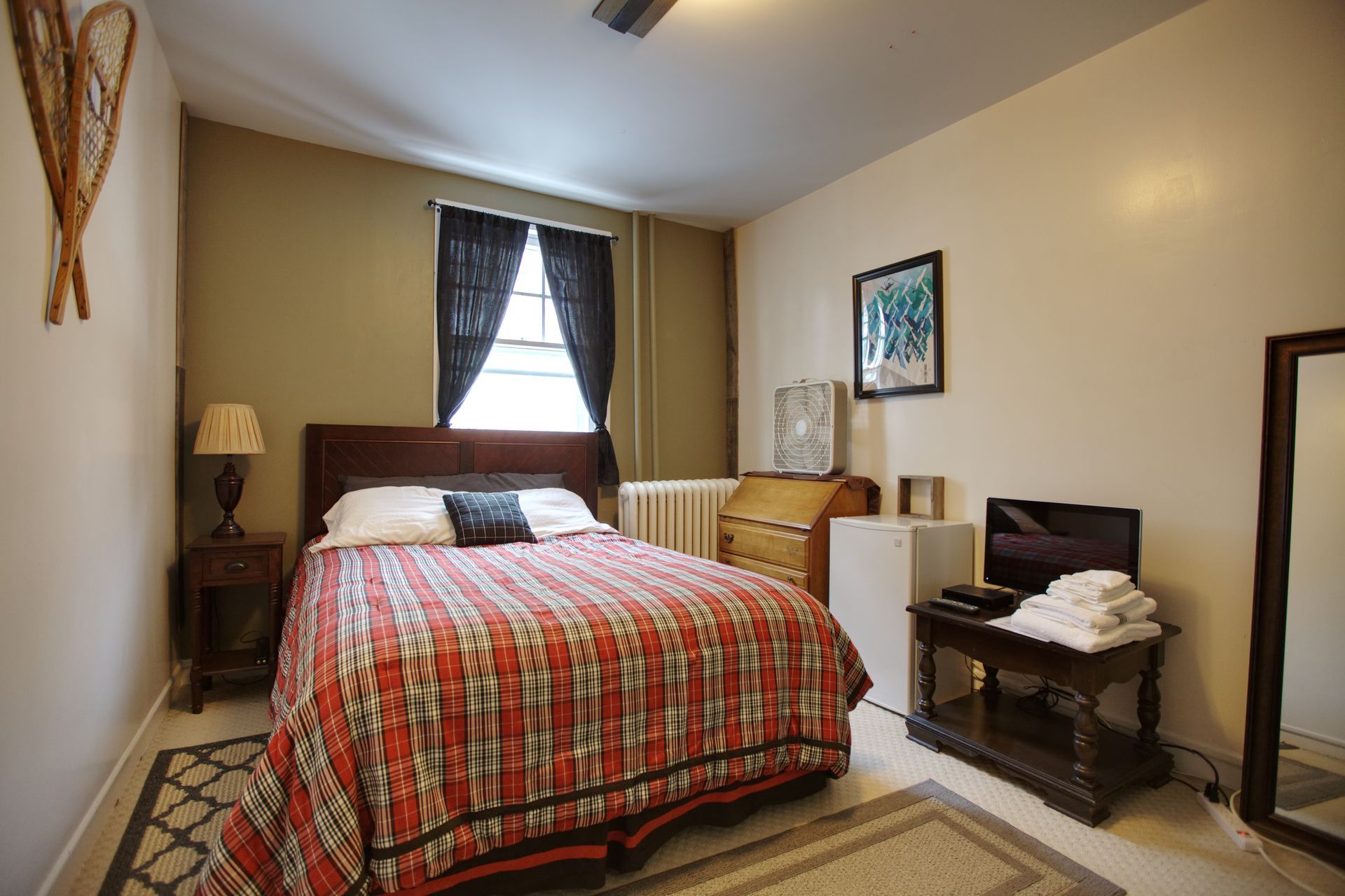 A bedroom with a king size bed and a mirror