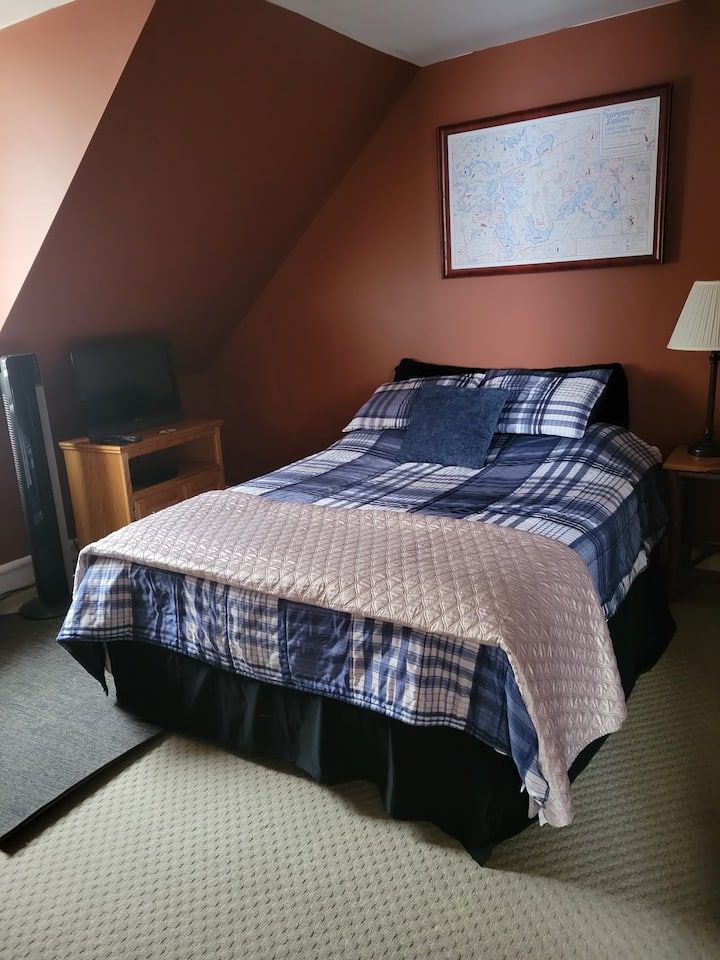 A bedroom with two beds , a desk , a chair and a ceiling fan.